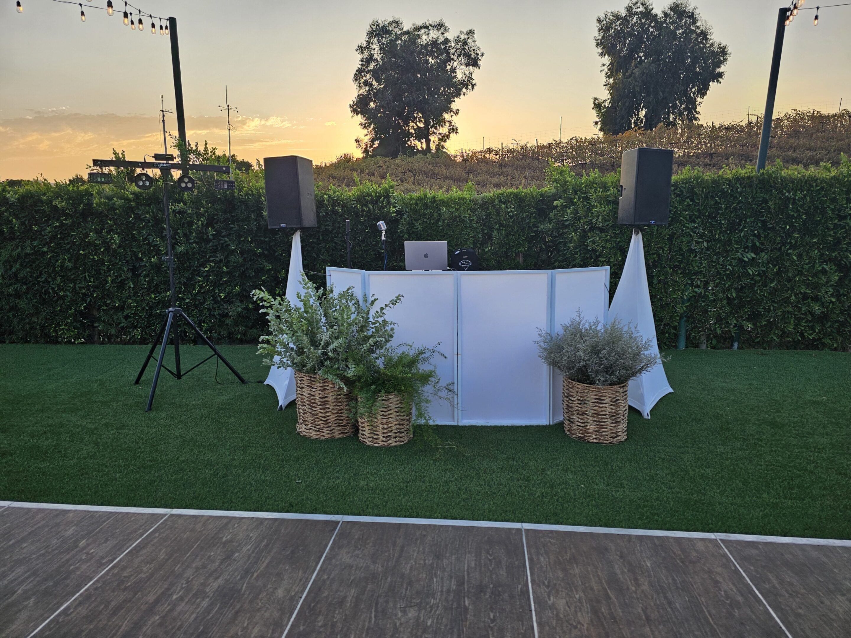 Outdoor wedding altar setup with floral decorations and candles at sunset.