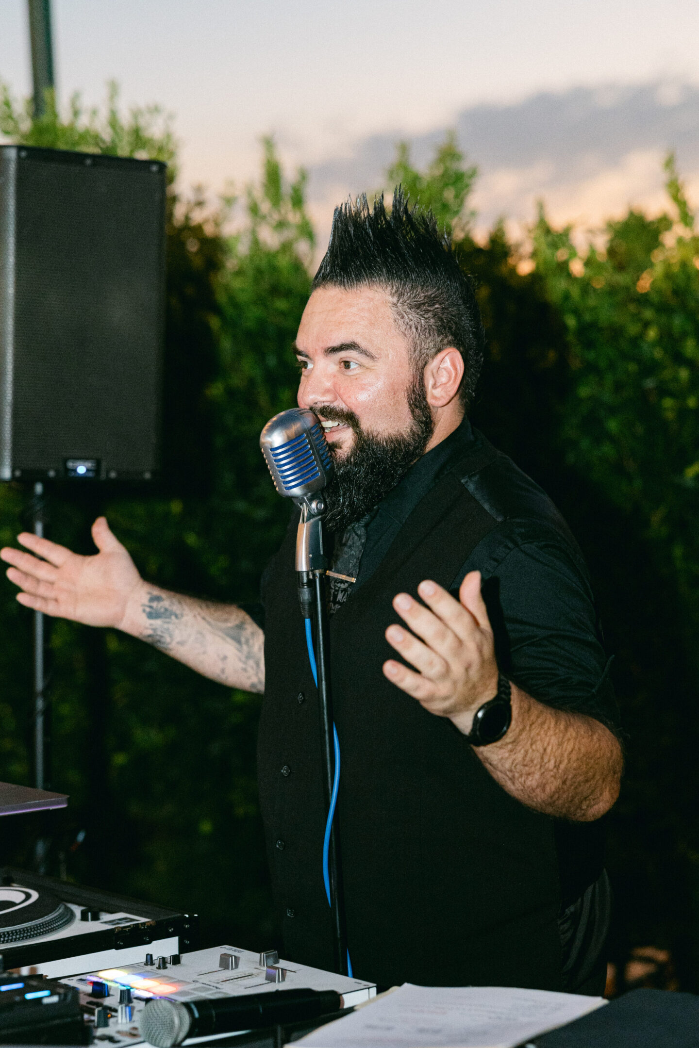 Man speaking passionately into a vintage microphone outdoors.